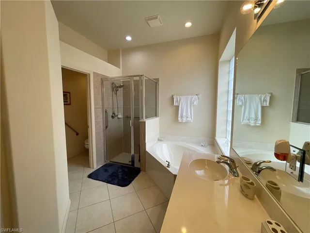 a bedroom with a bed and dresser with mirror