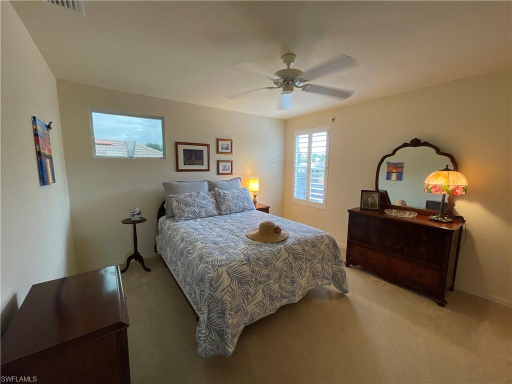 6478 Waverly Green Way Naples, FL 34110 - Photo 22 of 28 a bedroom with a bed and a chandelier