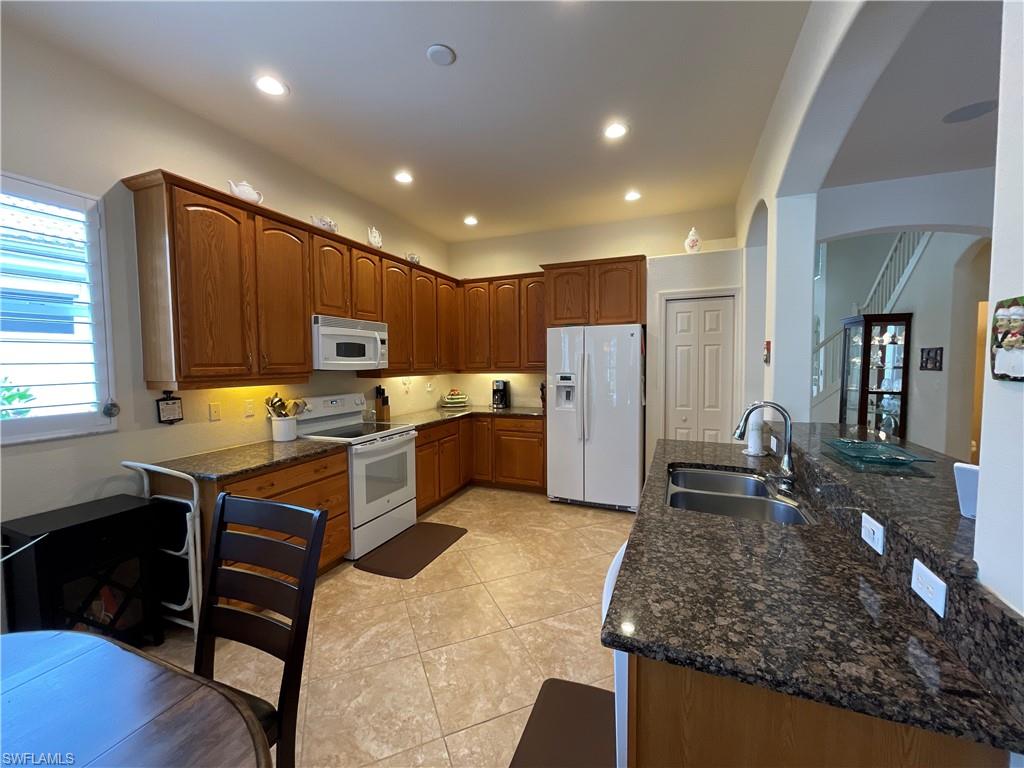 6478 Waverly Green Way Naples, FL 34110 - Photo 10 of 28 a kitchen with refrigerator and cabinets
