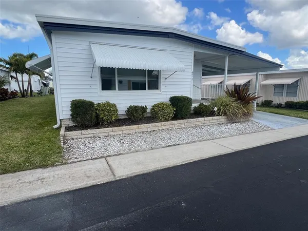 a front view of a house with a yard and potted plants