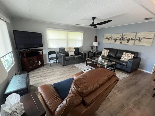 a living room with furniture and a wooden floor