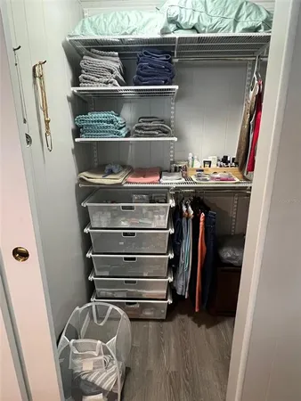 a view of walk in closet with clothes and shoes