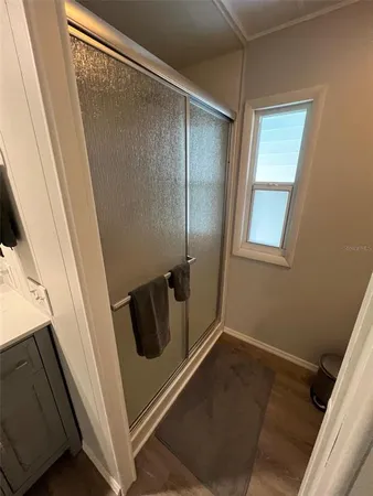a bathroom with a glass door shower and toilet