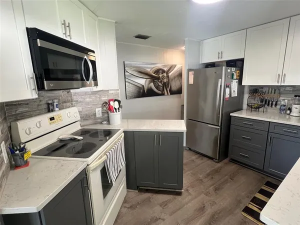a kitchen with a refrigerator and a stove top oven