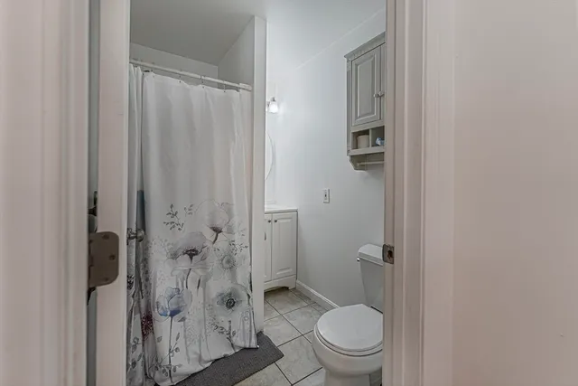 a bathroom with a granite countertop toilet a sink and shower