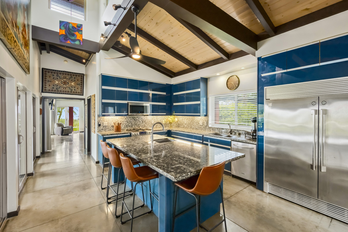 12-7124 Kalapana Kapoho Beach Road Pahoa, HI 96778 - Photo 9 of 30 a kitchen with stainless steel appliances granite countertop a table chairs and a refrigerator
