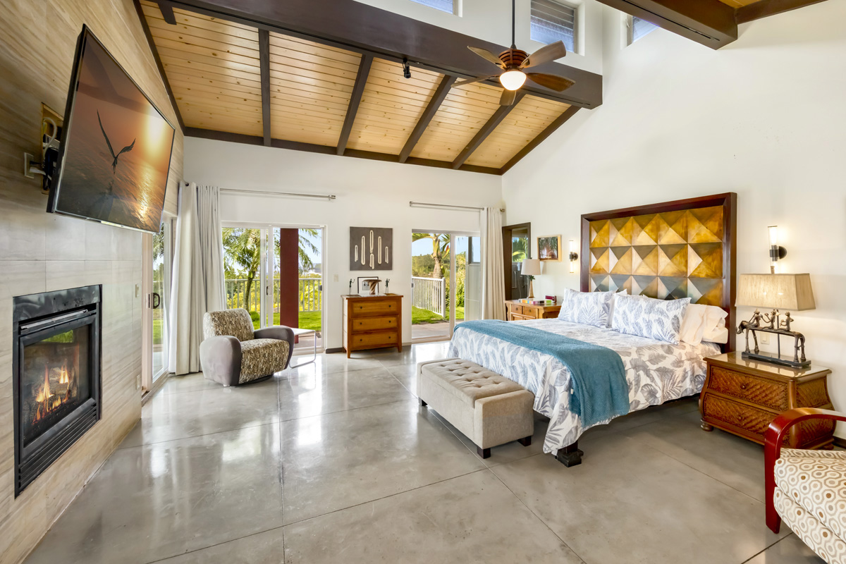 12-7124 Kalapana Kapoho Beach Road Pahoa, HI 96778 - Photo 10 of 30 a spacious bedroom with a balcony a bed a dresser next to a window