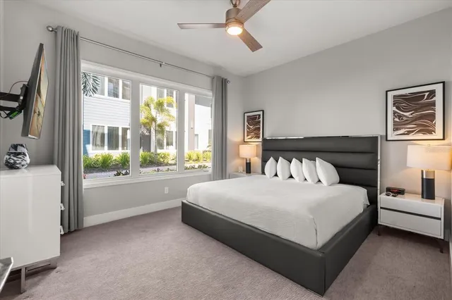 a large white bed sitting in a room next to a window