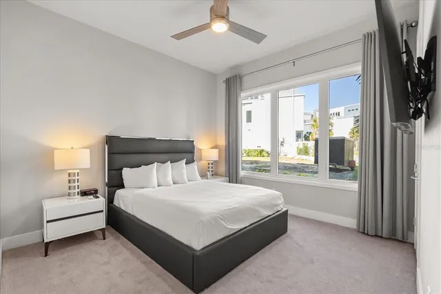 a bedroom with a large bed and a chandelier fan