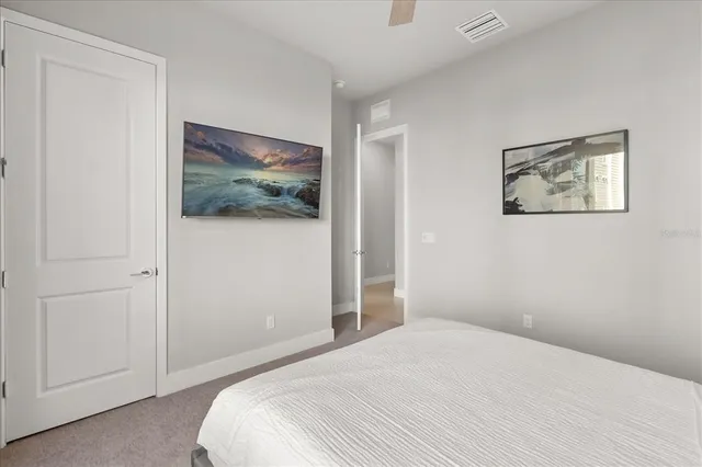 a bedroom with a bed and painting on the wall