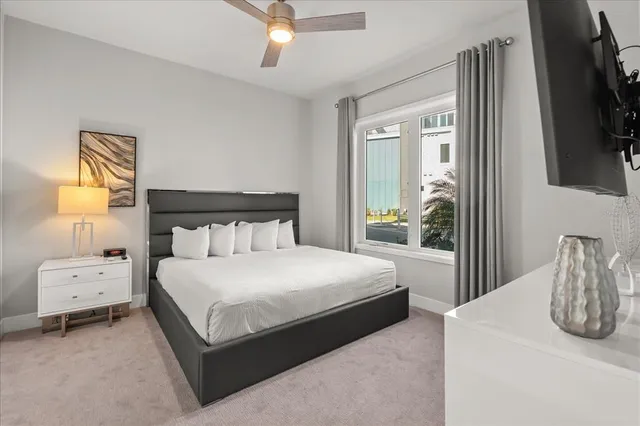 a bedroom with a bed and a flat tv screen on dresser