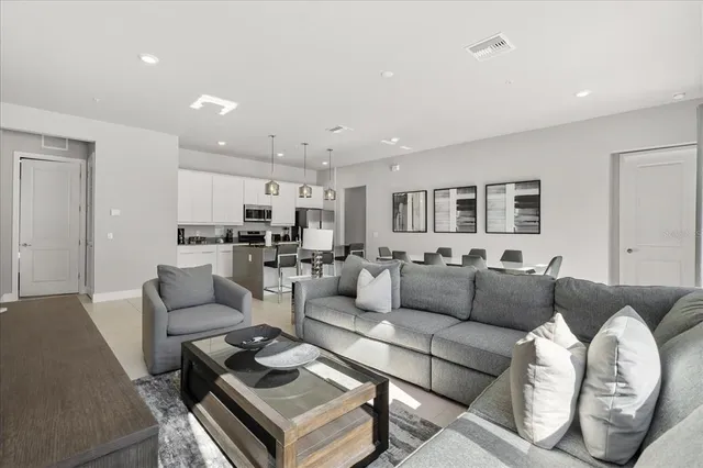 a living room with furniture and a view of kitchen