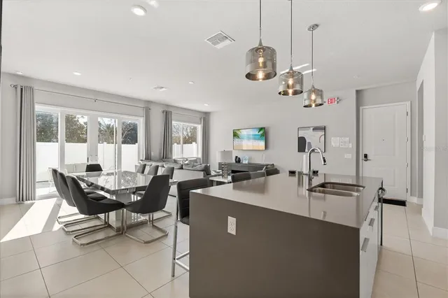 a dining room with wooden floor a chandelier a wooden table and chairs