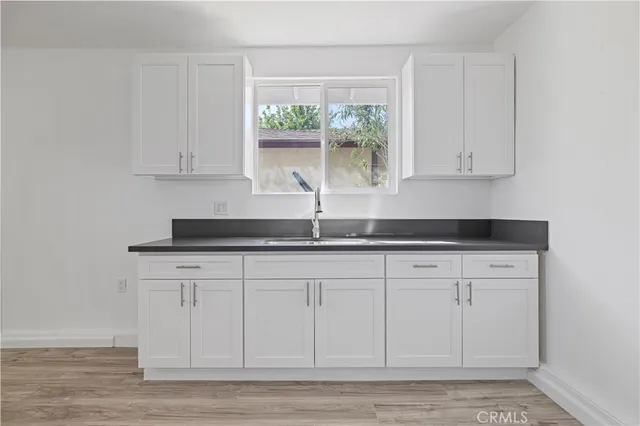 a kitchen with granite countertop white cabinets and stainless steel appliances