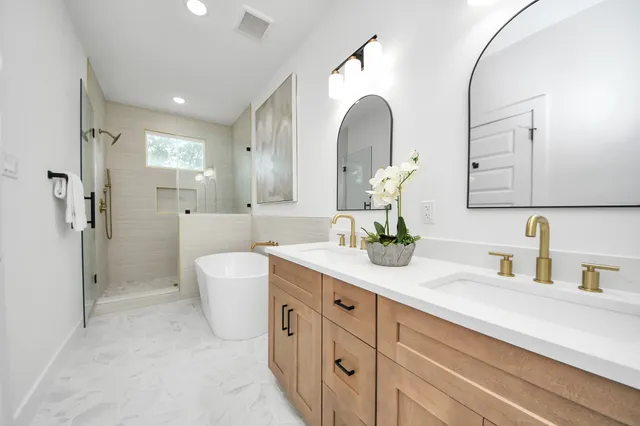 a spacious bathroom with a double vanity sink mirror and shower