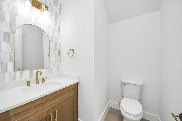 a bathroom with a sink vanity mirror and toilet