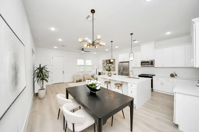 a kitchen with stainless steel appliances kitchen island a table and chairs in it