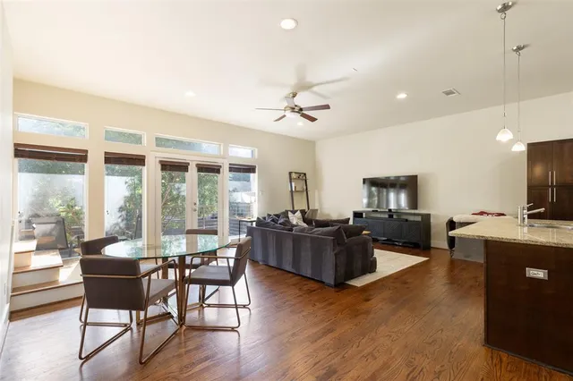 a living room with furniture a flat screen tv and wooden floor