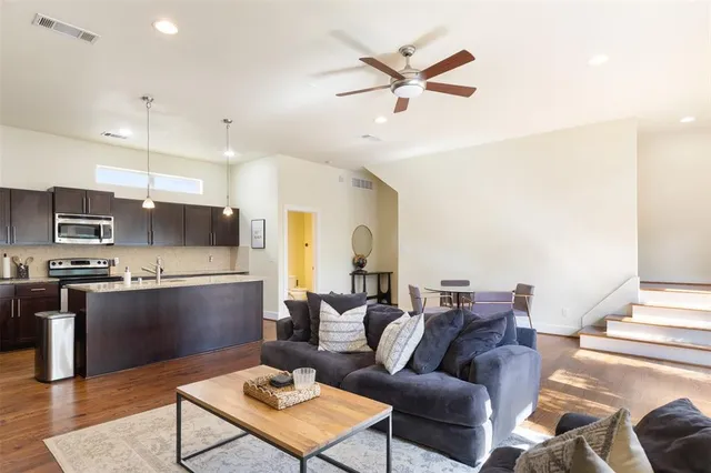 a living room with stainless steel appliances kitchen island furniture and a view of kitchen