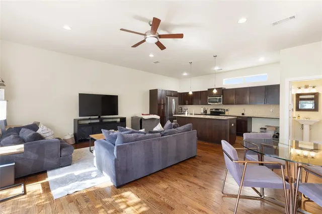 a living room with furniture kitchen and a flat screen tv