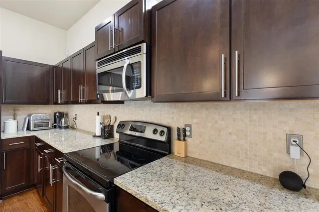 a kitchen with stainless steel appliances granite countertop a sink stove and microwave