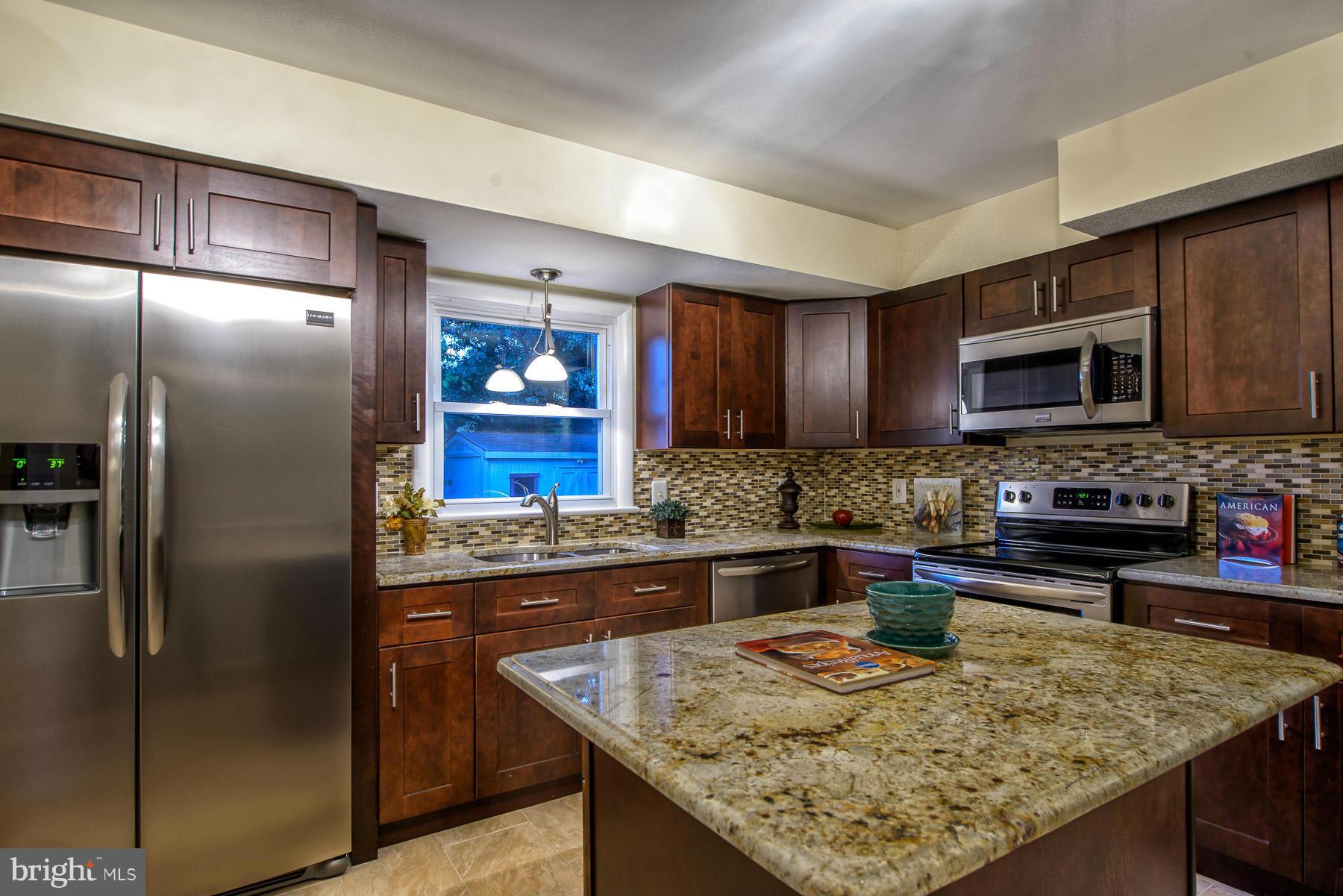 a kitchen with stainless steel appliances granite countertop a refrigerator oven a sink and dishwasher