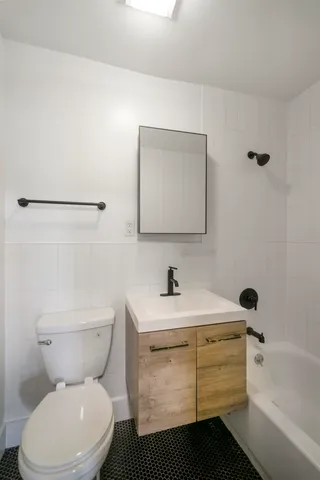 a bathroom with a toilet sink and mirror
