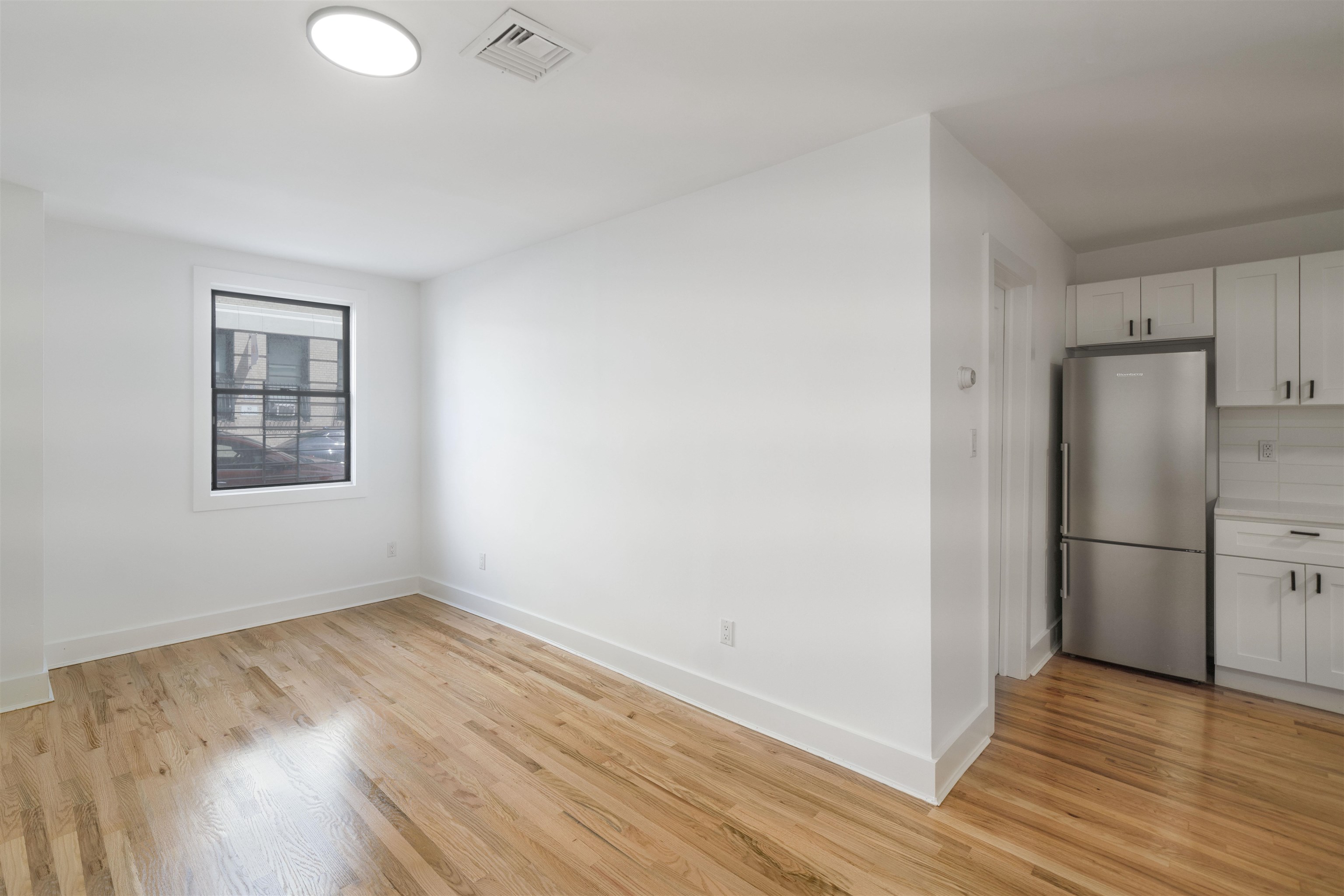 163 3rd Street, Unit 1A Hoboken, NJ 07030 - Photo 2 of 12 a view of a kitchen with wooden floor and a refrigerator