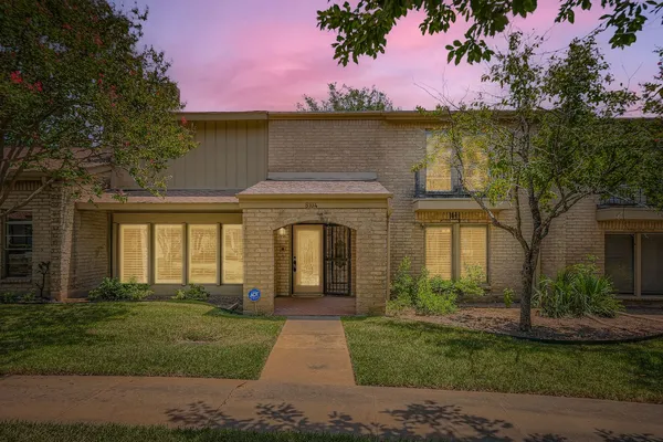 a front view of a house with a garden and yard