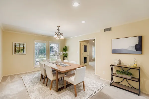 a view of a dining room with furniture and chandelier