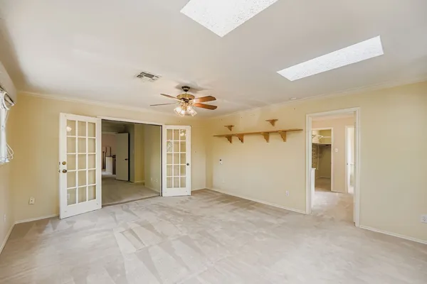 a view of a livingroom with a chandelier fan and windows