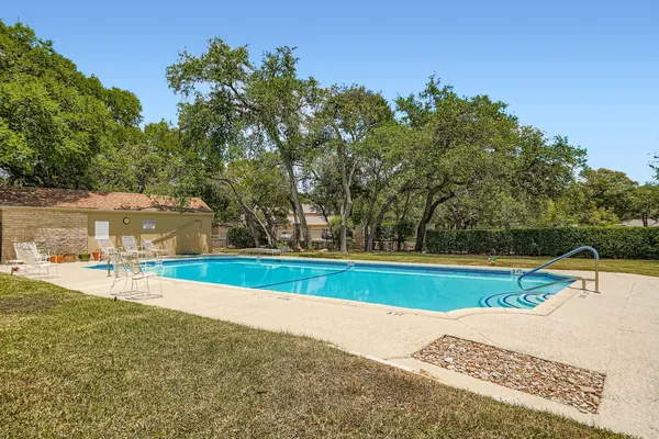 a view of a swimming pool with an outdoor seating and a garden