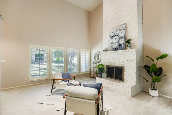 a living room with furniture a fireplace and potted plants