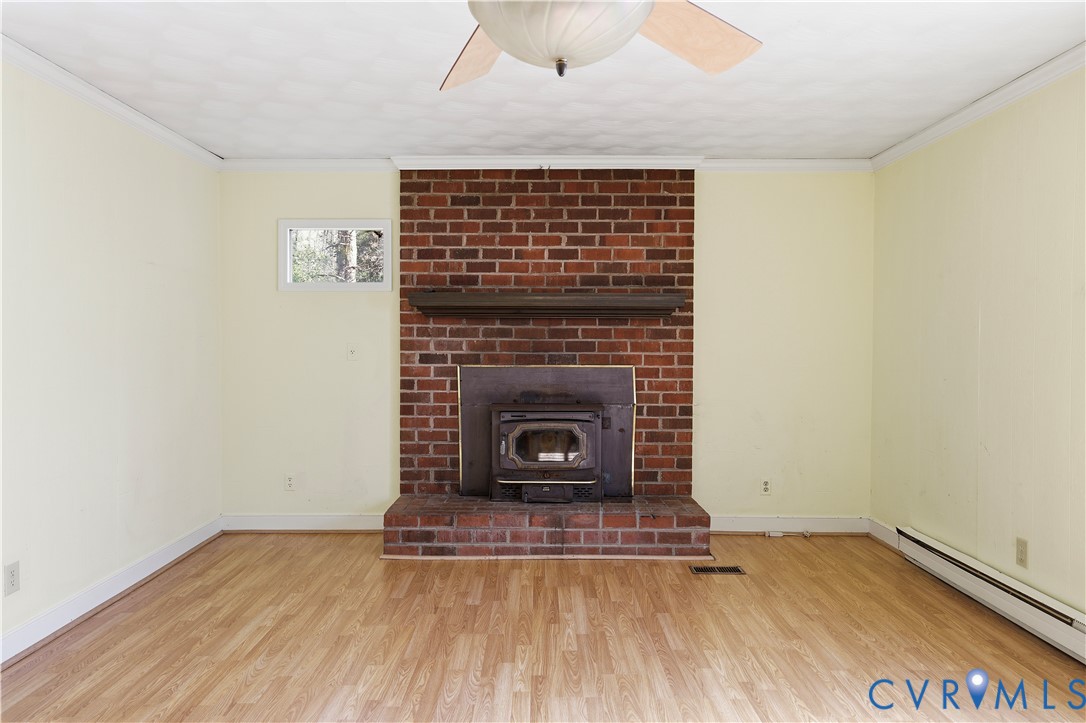 11352 Rockville Road Rockville, VA 23146 - Photo 19 of 38 a view of an empty room with wooden floor a fireplace and a window