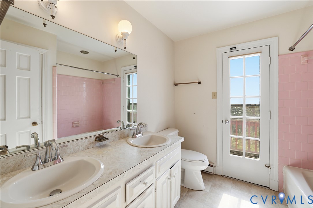 11352 Rockville Road Rockville, VA 23146 - Photo 25 of 38 a bathroom with a double vanity sink a toilet and a mirror