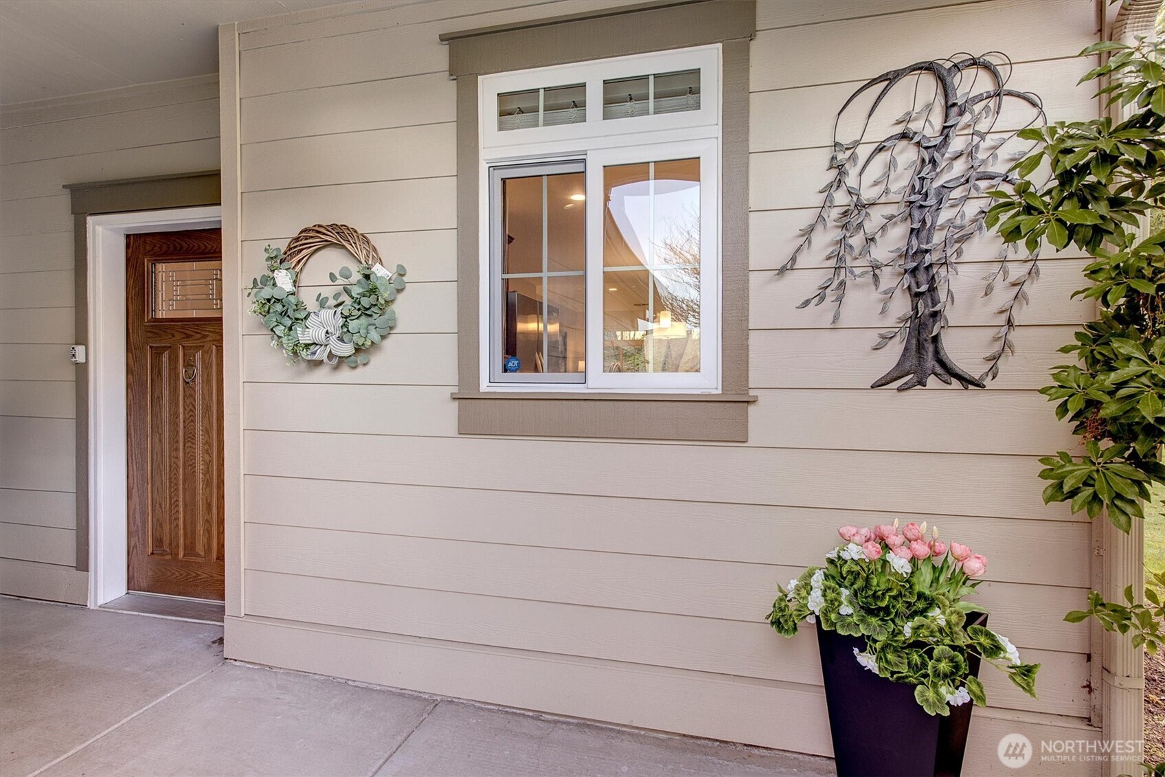 23857 Northeast 112th Circle, Unit 2 Redmond, WA 98053 - Photo 3 of 28 a vase with flowers sitting on a window sill and a wooden door