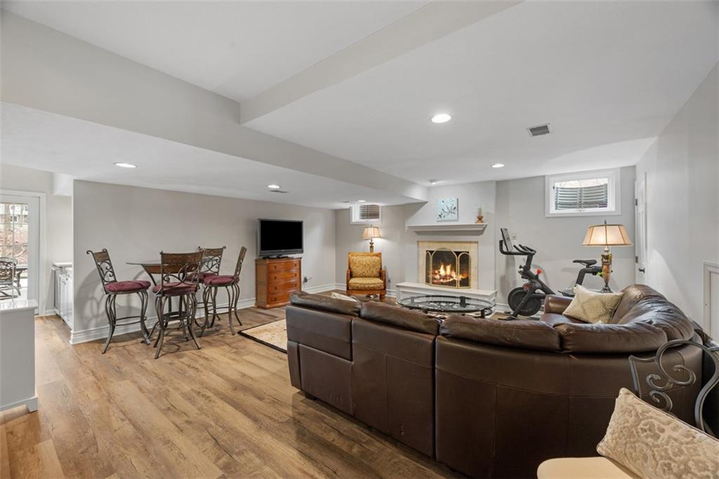 317 Blue Run Road Cheswick, PA 15024 - Photo 38 of 50 Luxury vinyl plank flooring through lower level and attractive fireplace (fire is virtual staging)