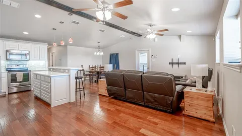 a kitchen with kitchen island white cabinets and stainless steel appliances