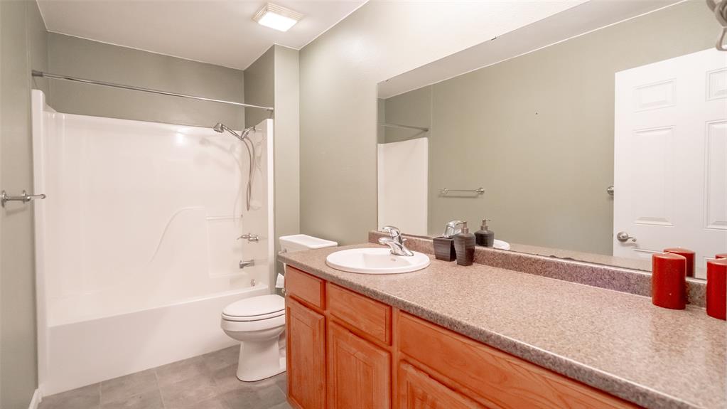 659 Aviator Drive Fort Worth, TX 76179 - Photo 33 of 40 a bathroom with a granite countertop sink toilet and shower