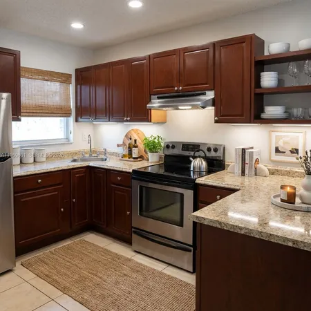 a kitchen with granite countertop a sink stove and cabinets
