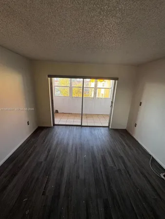 a spacious bedroom with a bed a couch and potted plant on the dresser