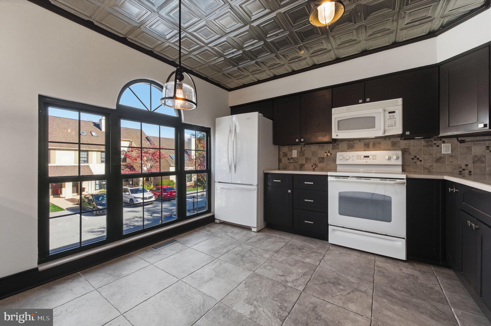 3305 Keswick Way, Unit 3305D Newtown Square, PA 19073 - Photo 18 of 38 a kitchen with stainless steel appliances granite countertop a stove a sink and a microwave