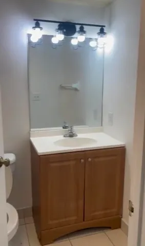 a bathroom with a sink vanity and a toilet