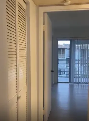 a view of a hallway with wooden walls