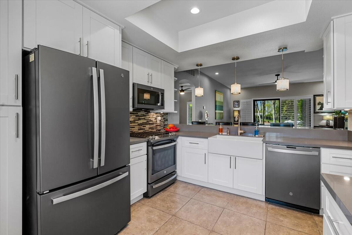 67527 North Portales Drive Cathedral City, CA 92234 - Photo 11 of 47 a kitchen with white cabinets and stainless steel appliances