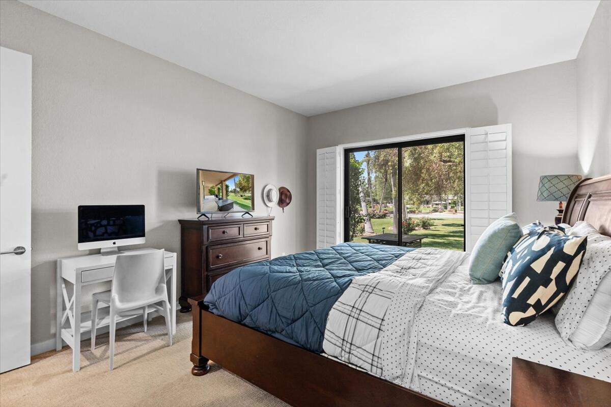 67527 North Portales Drive Cathedral City, CA 92234 - Photo 20 of 47 a bedroom with a bed a chair and a flat tv screen on the dresser