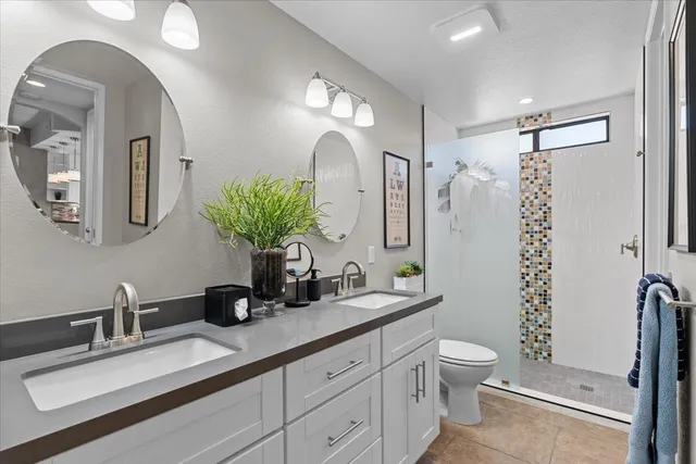 a en suite bathroom with a double vanity sink and a mirror
