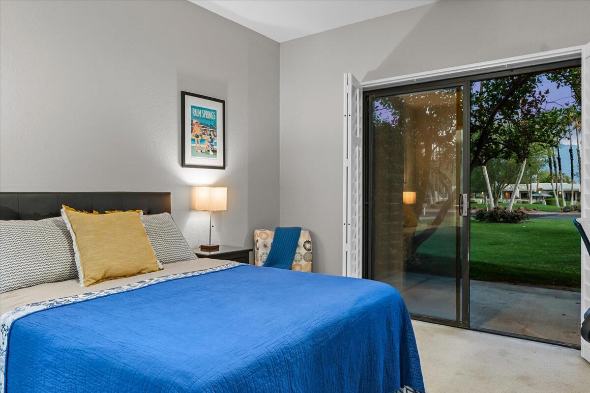 67527 North Portales Drive Cathedral City, CA 92234 - Photo 34 of 47 a bedroom with a bed and a large window with garden view
