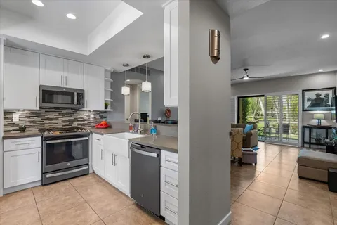 a kitchen with white cabinets and stainless steel appliances