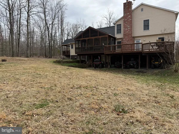 a view of a house with a yard and large trees